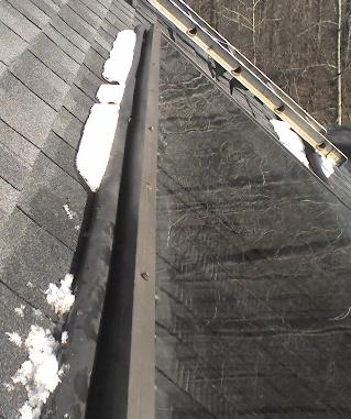 Photo showing snow on top of panel before we installed flashing. Leaves would also cause damage to the roof if allowed to be trapped behind the solar panel